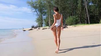 Sexy teen on a beach teasing with her ass in one piece bikini